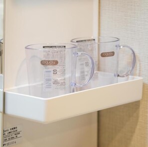 A clear glass mug with a handle and a label, placed on a white shelf. - Dc Sakura Hotel - Namba South Branch (Osaka)