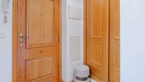 Une porte en bois avec une poignée, un petit tabouret et un climatiseur fixé au mur.