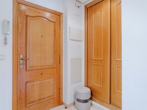 A wooden door with a handle, a small stool, and a wall-mounted air conditioning unit. - Jardines del Rio by Interhome (Jávea)