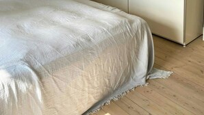 A bedroom with a bed, a wardrobe, and a hanging light fixture. - Classic apartment with a balcony in Amagerbro (København)