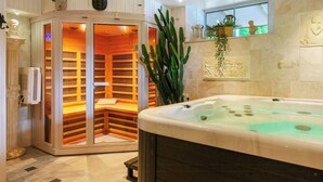 A spa room with a hot tub, a sauna, and a cactus plant. - 1929 villa with pool and spa by Lake Hällungen (Svenshögen)