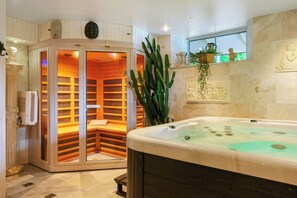 Un cuarto de spa con un jacuzzi, una sauna y una planta de cactus.