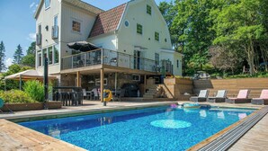 A two-story house with a swimming pool, outdoor furniture, and a covered patio area. - 1929 villa with pool and spa by Lake Hällungen (Svenshögen)