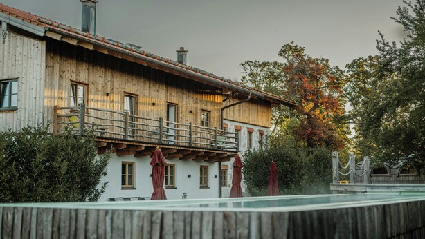 A wooden building with a balcony, windows, and a fence. - Living among orchards by Lake Chiemsee (Übersee)