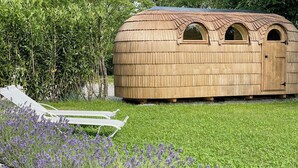 A wooden structure with a rounded roof, a door, and two arched windows. - Living among orchards by Lake Chiemsee (Übersee)