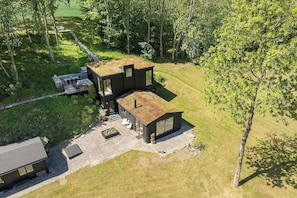 A modern two-story house with a flat roof, a patio area, and a surrounding natural landscape. - Summerhouse close to nature by The Limfjord (Nykøbing Mors)