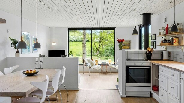 A modern kitchen with a large window, white cabinetry, and a central island. - Summerhouse close to nature by The Limfjord (Nykøbing Mors)