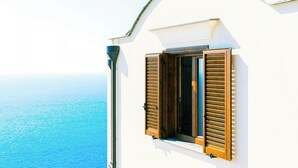 A white building with a window and shutters, overlooking a body of water. - Baroque house with lemon groves in Amalfi (Amalfi)