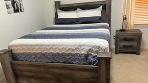 A bed with a wooden frame, a headboard, and a bedside table with drawers.