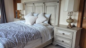 A bedroom with a bed, nightstands, and a dresser.
