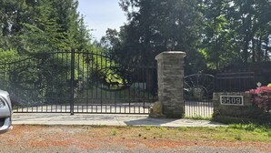 A gated entrance with a stone pillar and a metal gate.