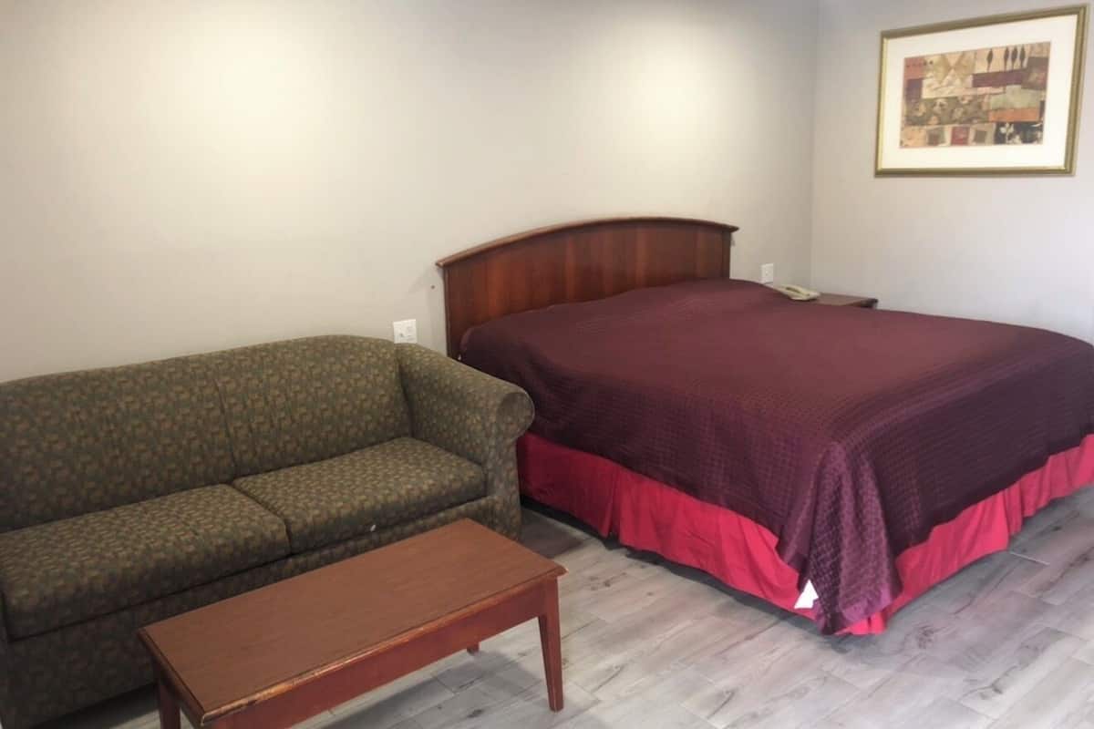 A room with a bed, a sofa, and a small table.