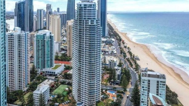 A coastal cityscape with high-rise buildings, a beach, and a clear view of the ocean. - Drift n Dream Apartment w/Free Parking+Pool+Gym (Surfers Paradise)
