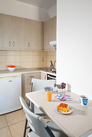Eine moderne Küche mit Essbereich, darunter ein Tisch mit einer Schale Essen, einer Tasse und einer Fruchtschale.