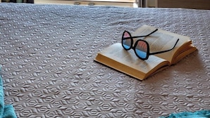 A room with a bed, an open book, and a pair of glasses on the bed. - Fodele Beach Front Apts. (Malevizi)
