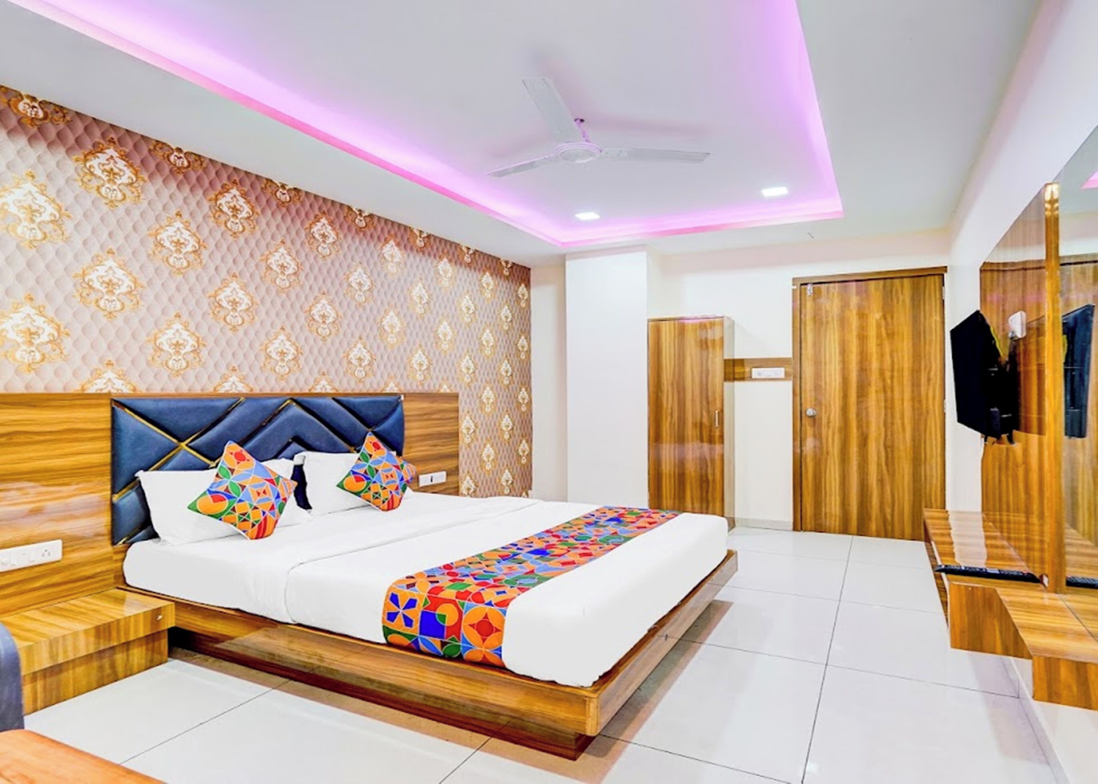 A modern bedroom with a bed, a ceiling fan, and wooden wardrobe.