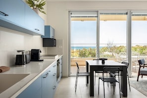 Una cocina moderna con comedor, un amplio ventanal corredera a un balcón y vistas al exterior.