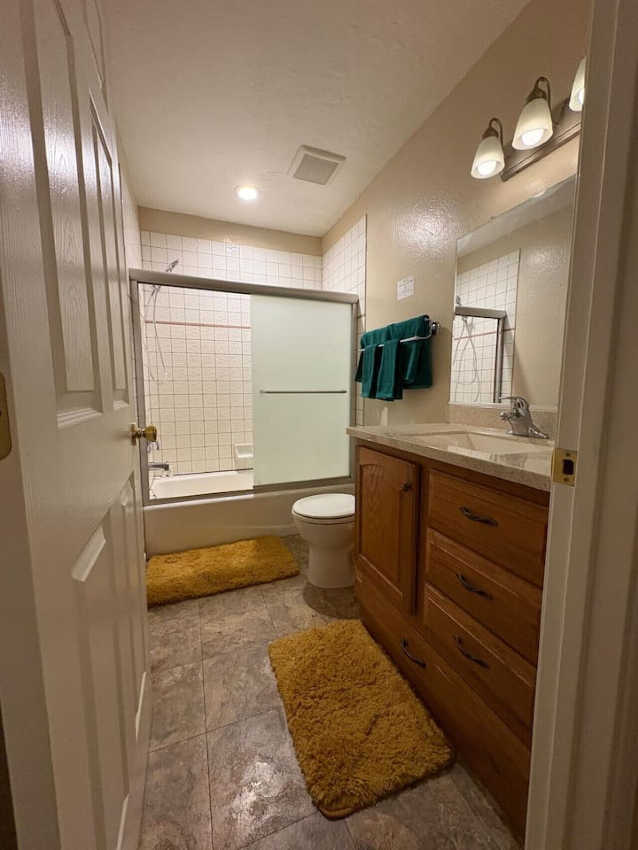 Une salle de bain équipée d’une douche, de toilettes, d’un lavabo et d’un miroir.
