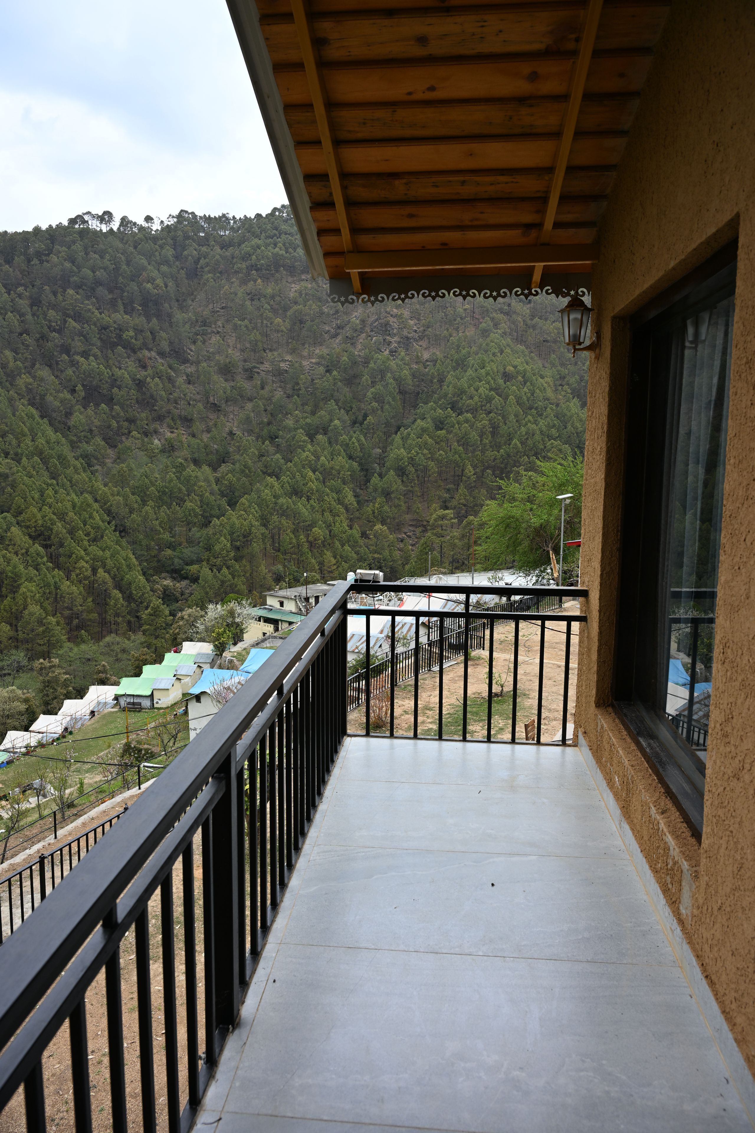 Ein Balkon mit Blick auf einen bewaldeten Hügel.