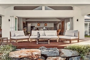 A modern outdoor seating area with a sofa set, a coffee table, and a decorative owl statue.