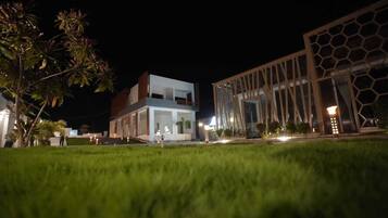 Un edificio moderno con fachada de vidrio, techo plano y fachada geométrica a la derecha.