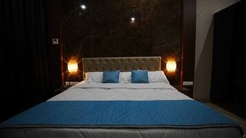 Una habitación de hotel con una cama grande, cabecera de mármol y dos lámparas de pared.