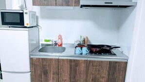 Une cuisine compacte équipée d’un four à micro-ondes, d’une cuisinière et d’un évier.