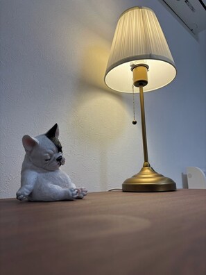 A small white dog figurine sitting next to a table lamp with a white shade and a gold base. - 7min walk to Shimbashi! JR & Ginza Line - Easy Access to All Tokyo & Ginza (港区)