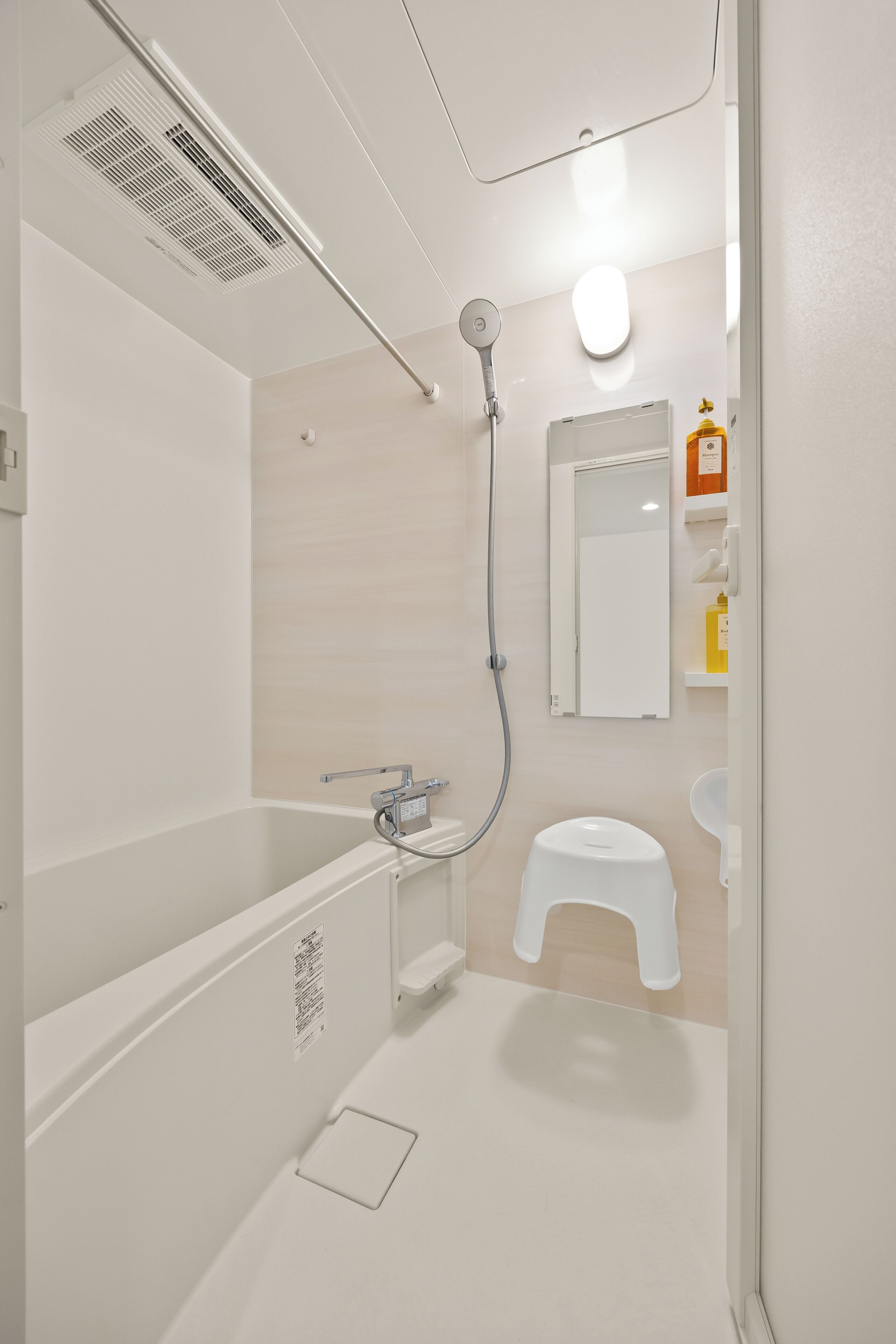 A modern bathroom with a bathtub, shower, toilet, and a mirror.