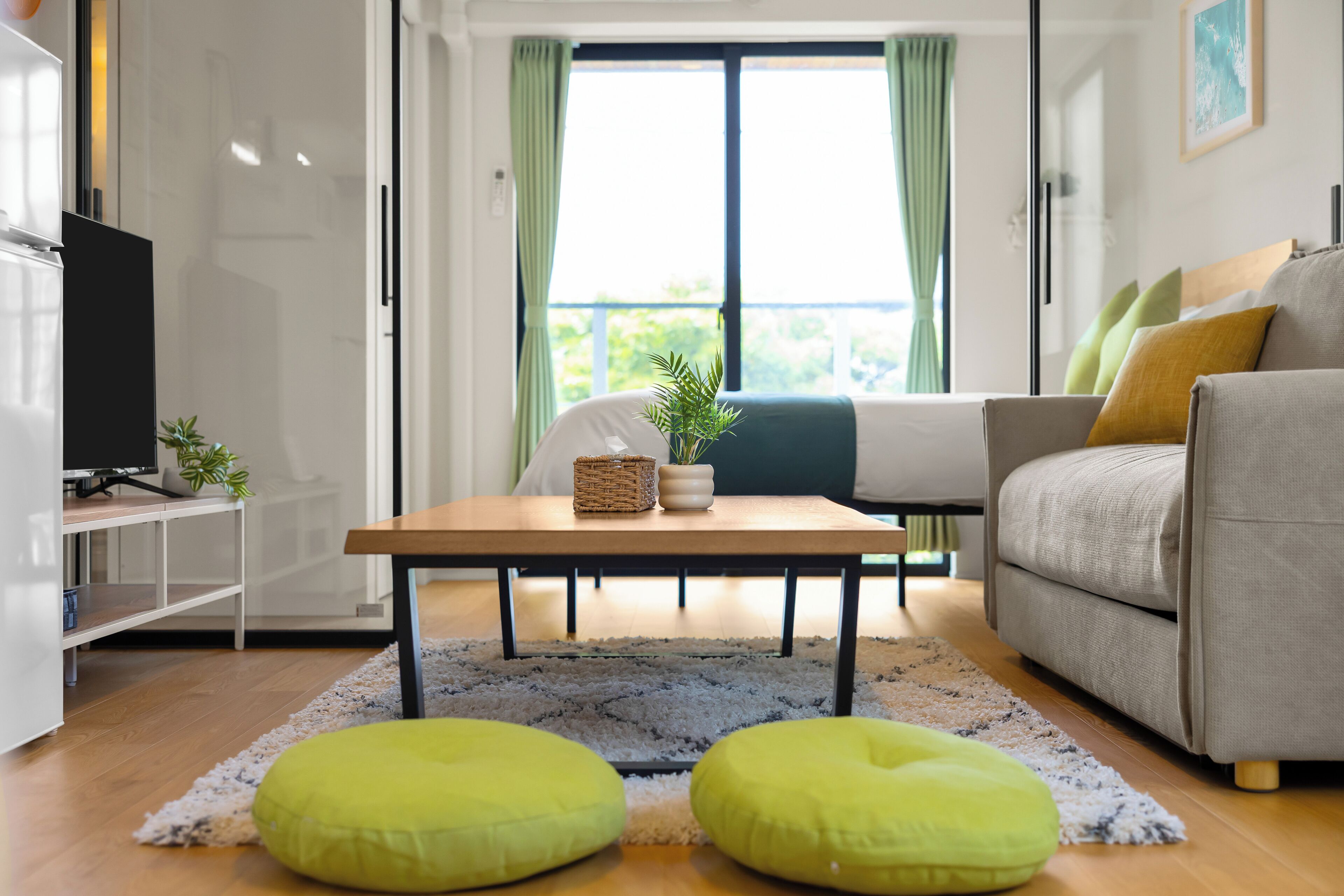 A modern living room with a sofa, a coffee table, and a television on a stand.