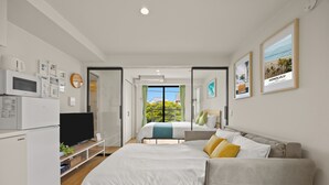 Ein modernes Schlafzimmer mit Bett, Fernseher, Schreibtisch und Fenster mit Blick.