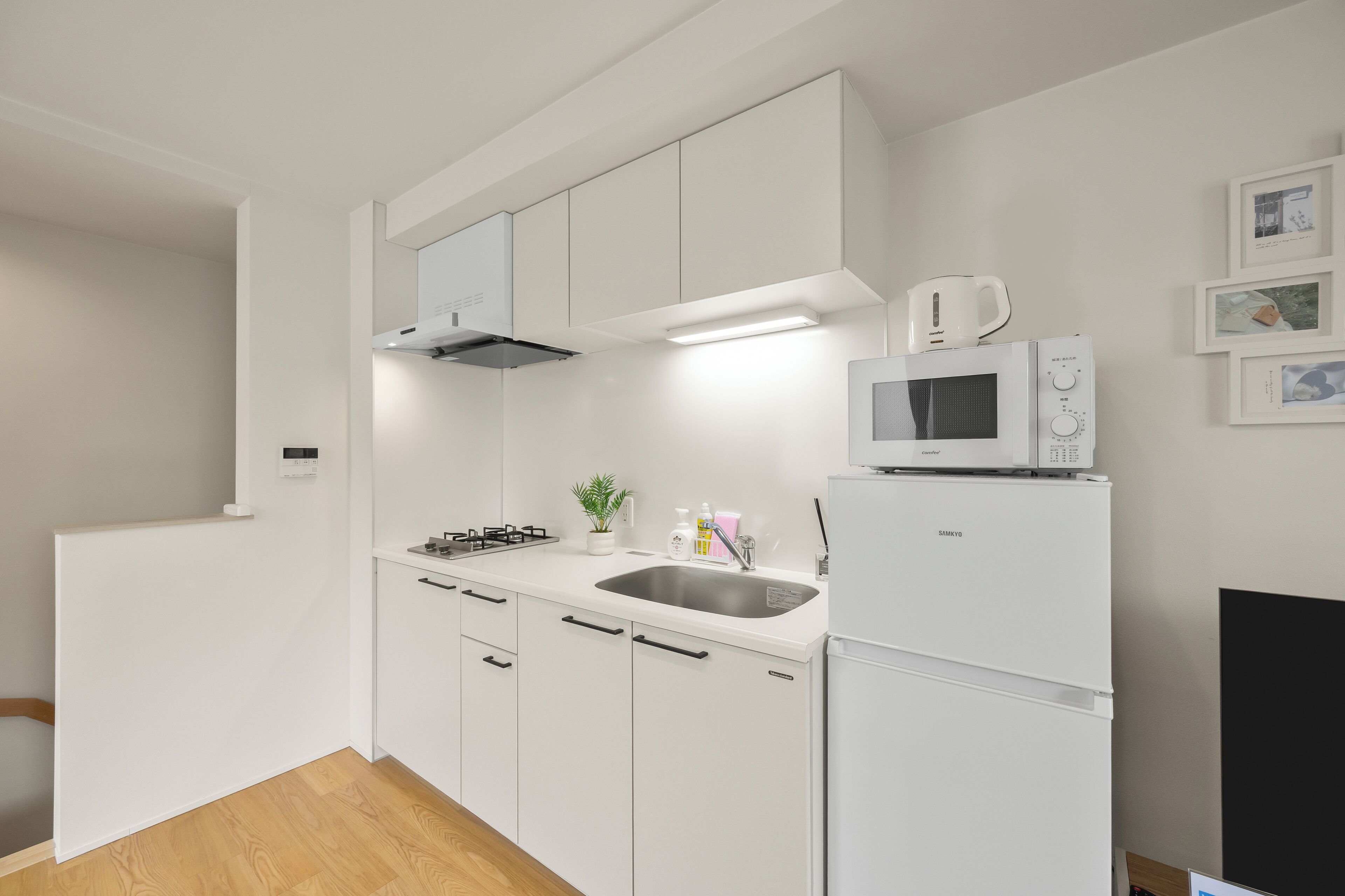 A modern kitchen with white cabinets, a built-in microwave, a gas stove, and a stainless steel sink.