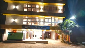 A building with a sign reading 'Andaman Beach Resort,' a covered entrance, and a palm tree in front. - Andaman Beach Resort (Port Blair)