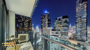 A balcony with a view of a cityscape at night, featuring tall buildings and a clear sky. - Exclusive Stays - SouthbankONE (Southbank)