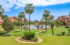 Ein Resort mit Schwimmbad, Palmen und einer gepflegten Rasenfläche.