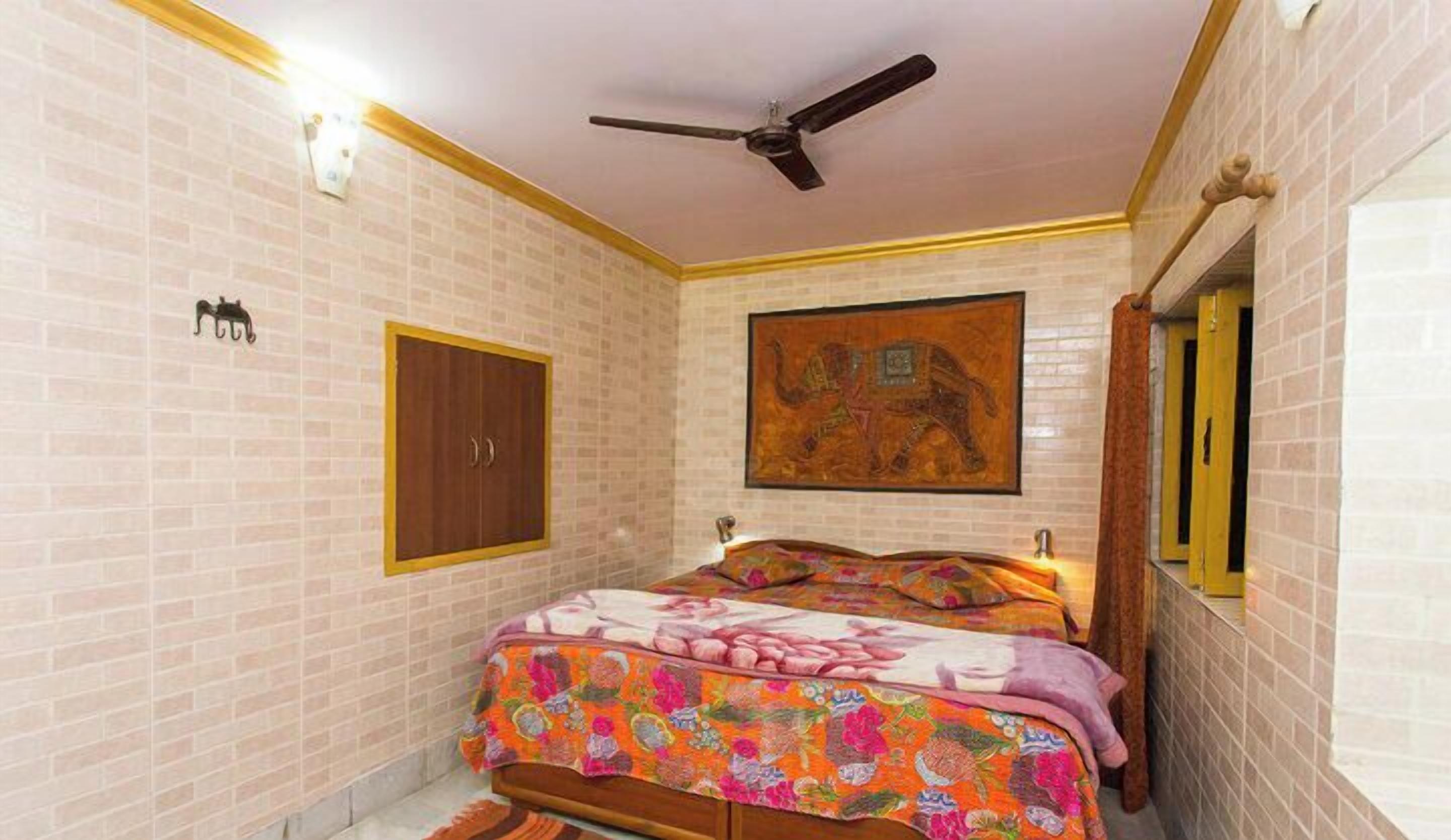 Un dormitorio con cama, ventilador de techo, armario y un cuadro en la pared.