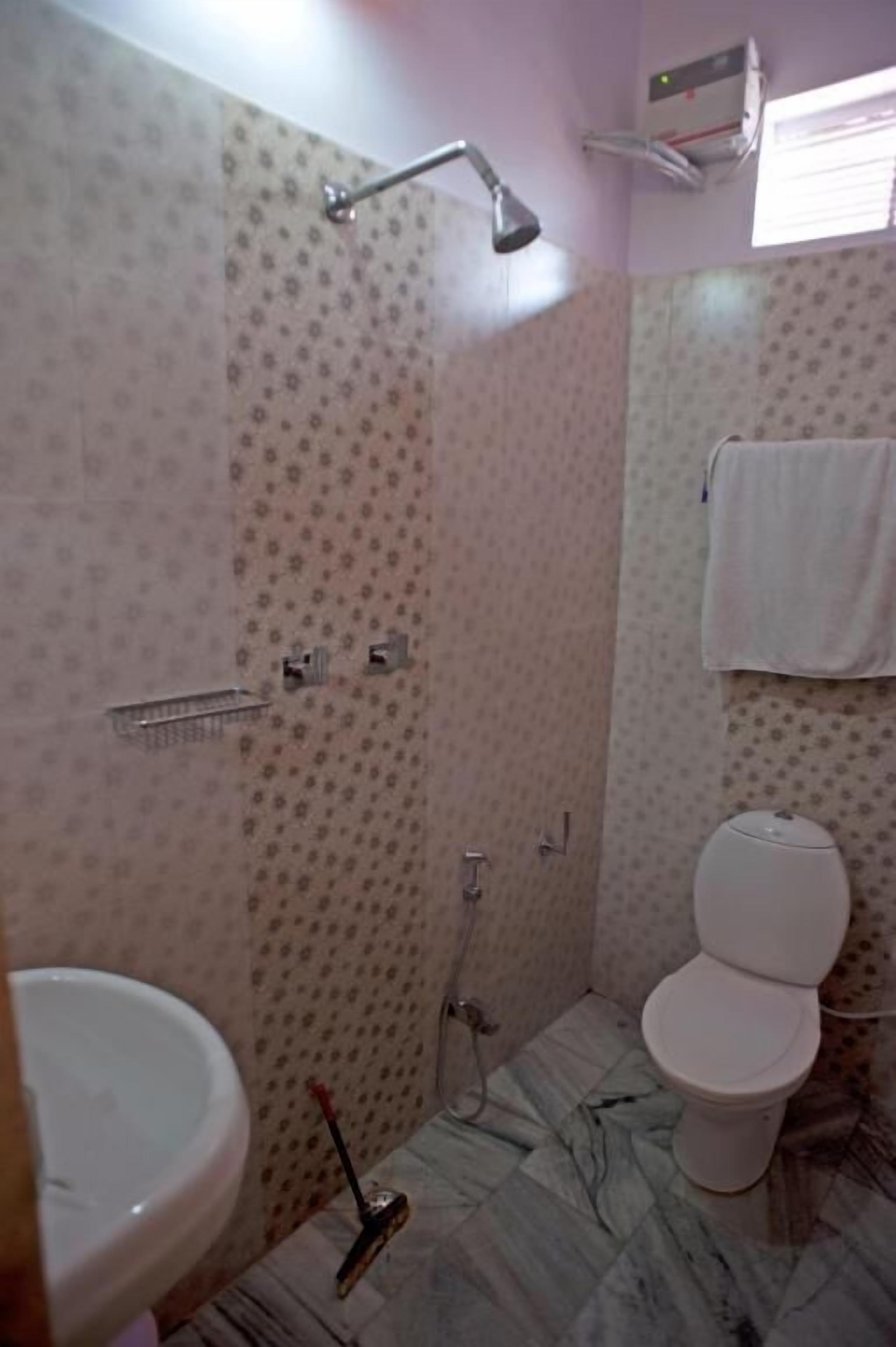 A bathroom with a toilet, bidet, and shower.