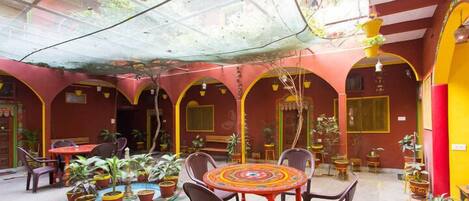 A courtyard with a round table, chairs, and potted plants.