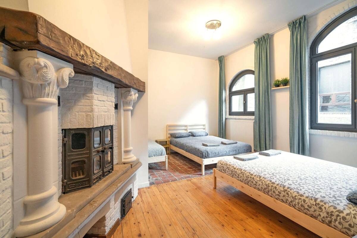 Una habitación con chimenea, cama, ventana y vistas al exterior.