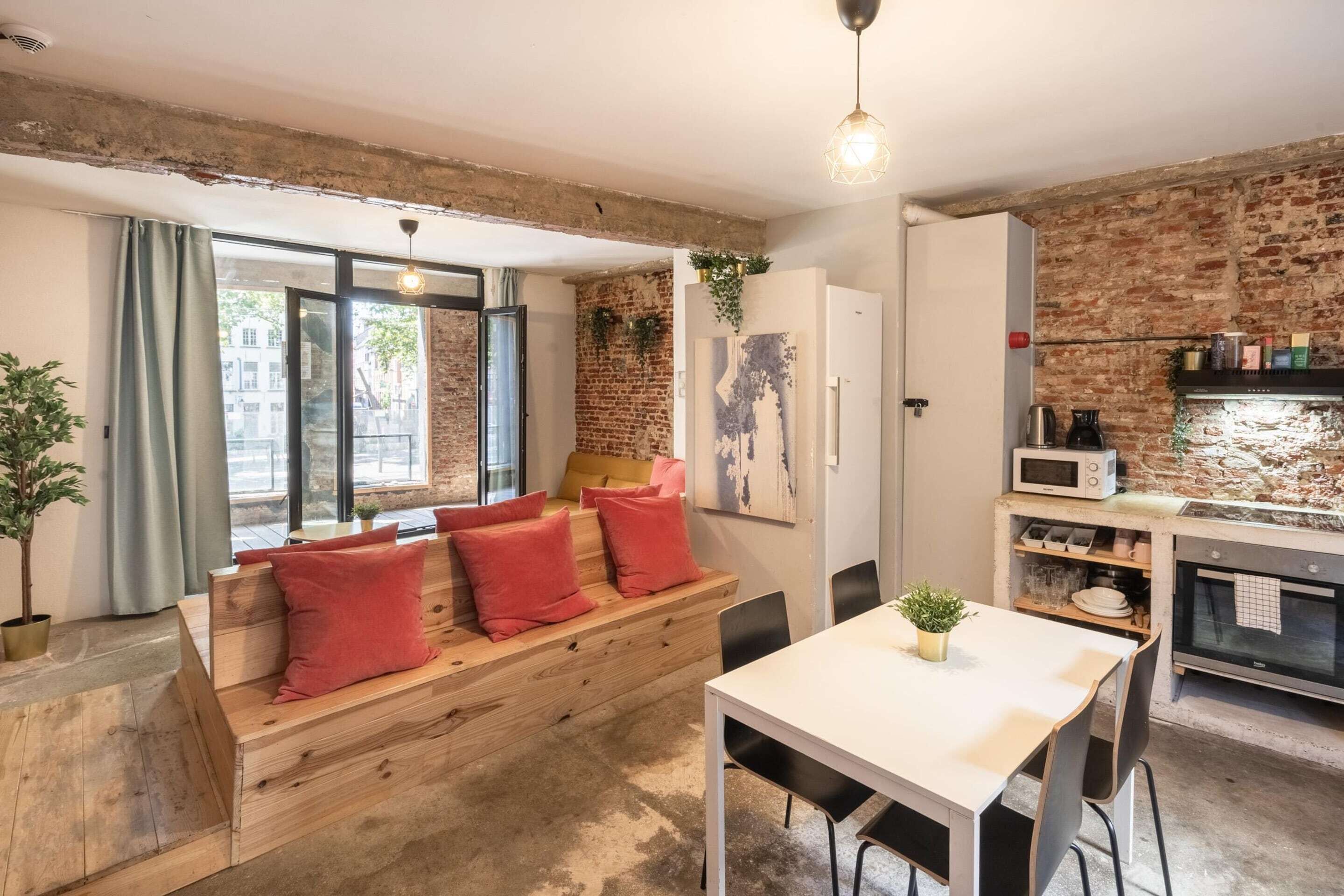 Une cuisine moderne avec un mur en briques, un banc en bois et une table à manger.