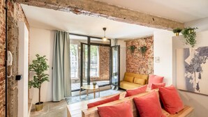 A modern living room with a sofa, a small table, and a potted plant. - The Industrial Apartments 2bbknsinternet (Antwerp)