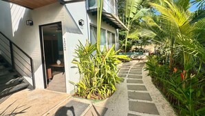 A modern building with a staircase leading to a door marked '102'. - Comfortable 2BR Condo in Coco at Nangu (Coco)