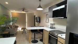 A modern kitchen with a central island, built-in oven, and a large refrigerator. - Comfortable 2BR Condo in Coco at Nangu (Coco)