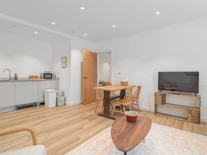 Een modern appartement met keuken, eethoek en woonkamer.