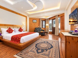 Una habitación de hotel con una cama grande, un escritorio, una silla y un televisor.