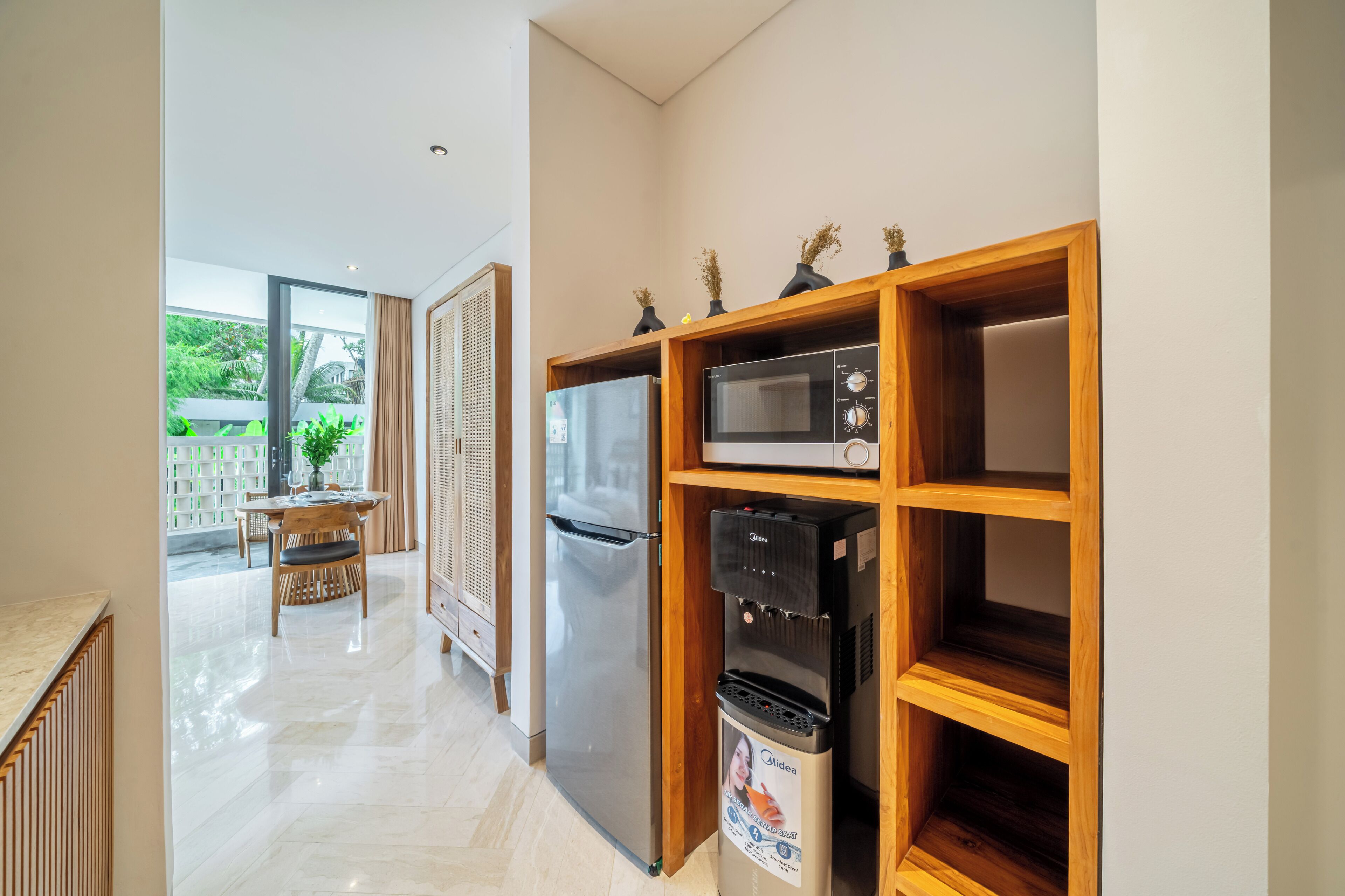 Una cocina moderna con refrigerador, microondas y dispensador de agua.