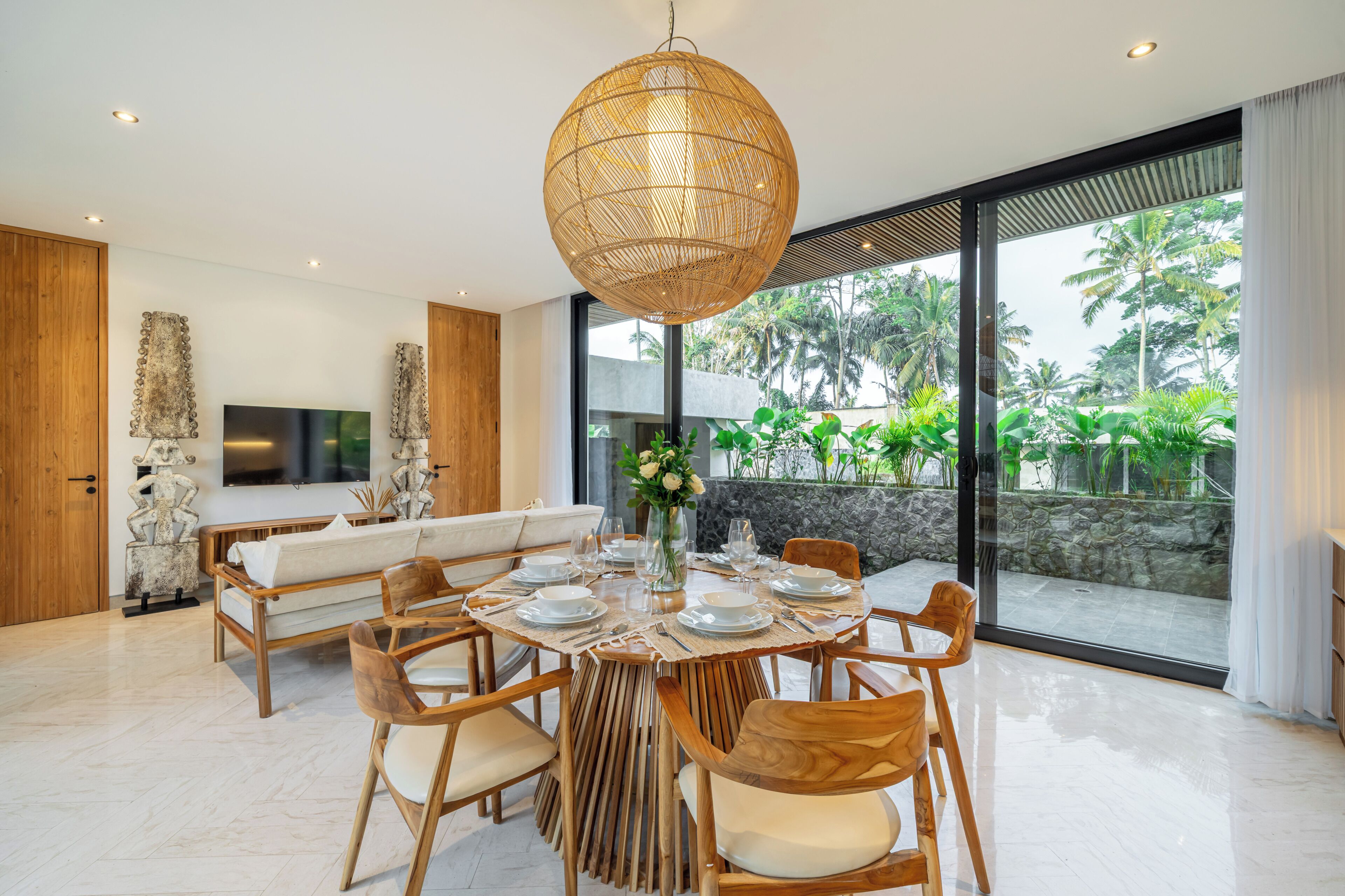 Un espace repas moderne avec une table ronde prévue pour six personnes, entourée de chaises en bois.