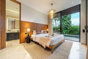 A modern bedroom with a large bed, bedside lamps, a mirror, and a view of greenery outside. - Happiness Residence Ubud (Ubud)