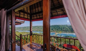 Une terrasse en bois offrant une vue sur un lac et des montagnes.