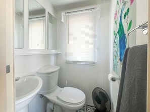 Un baño con inodoro, lavabo y zona de ducha.